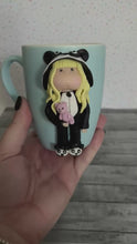 Load and play video in Gallery viewer, Handmade Polymer Clay 3D Blonde Girl in Panda PJs on a Blue Ceramic Mug
