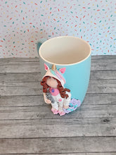 Load image into Gallery viewer, Handmade Polymer Clay 3D Girl in White Unicorn PJs on a Blue Ceramic Mug
